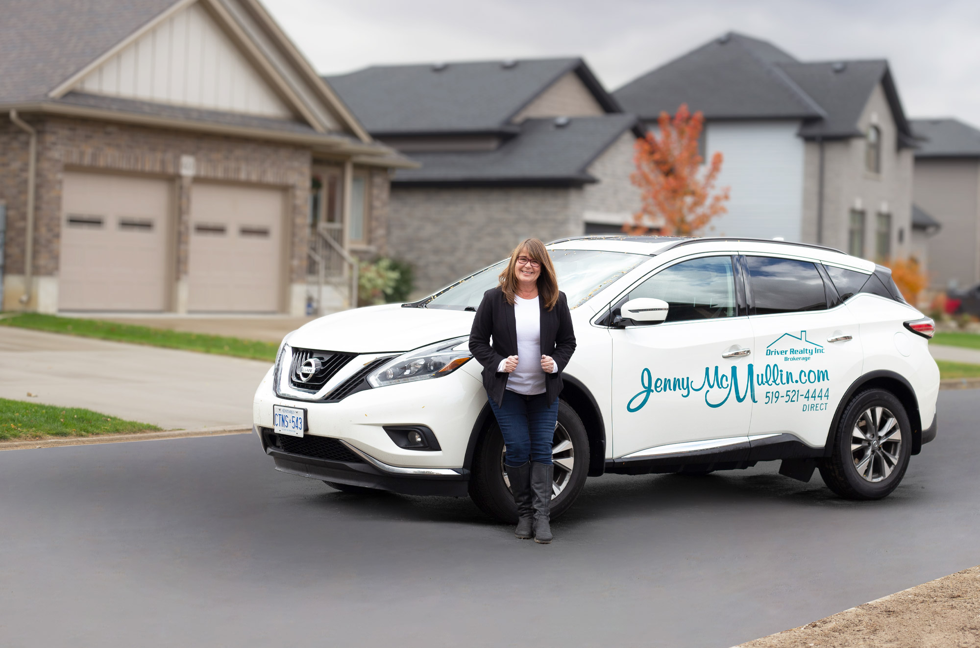 Jenny McMullin in front of a client home